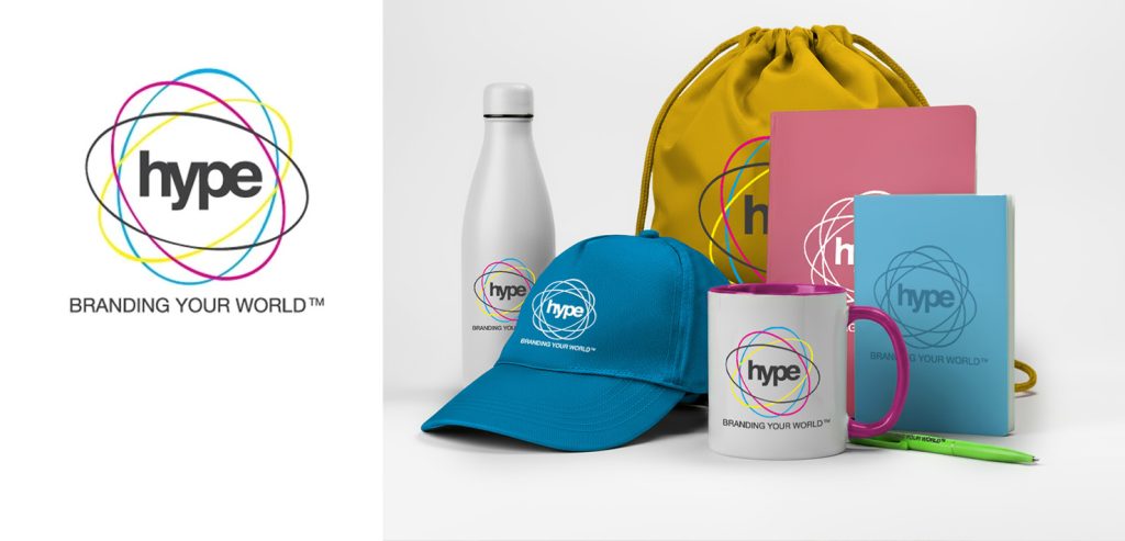 Hype Branding promotional image showing the Hype logo and slogan “Branding Your World” alongside a person carrying a branded tote bag with “Your Brand” printed on it.