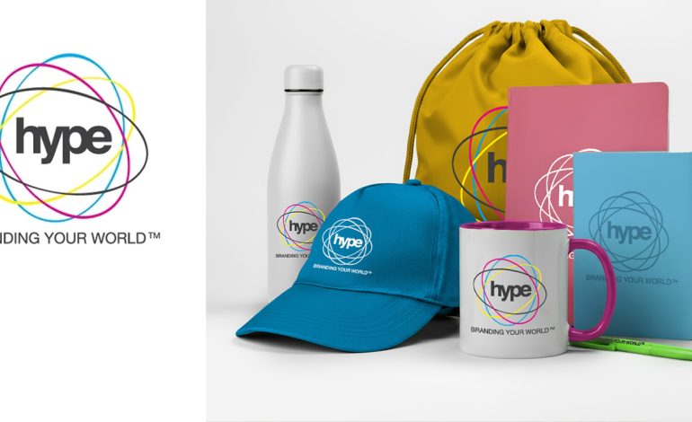 Hype Branding promotional image showing the Hype logo and slogan “Branding Your World” alongside a person carrying a branded tote bag with “Your Brand” printed on it.